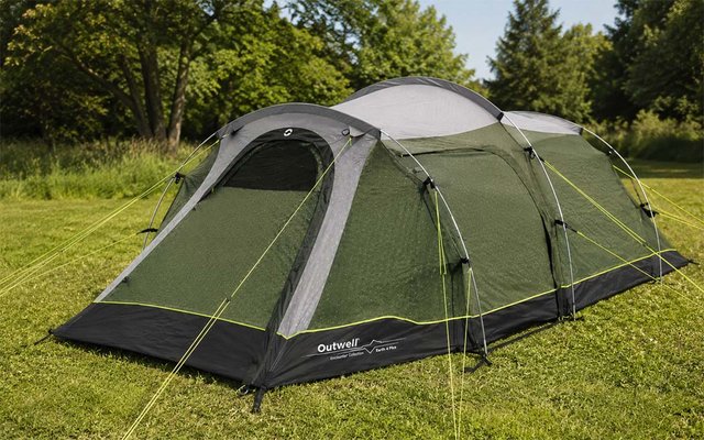 Groene tunneltent met grijs dak op gras, gele scheerlijnen, bomen op de achtergrond