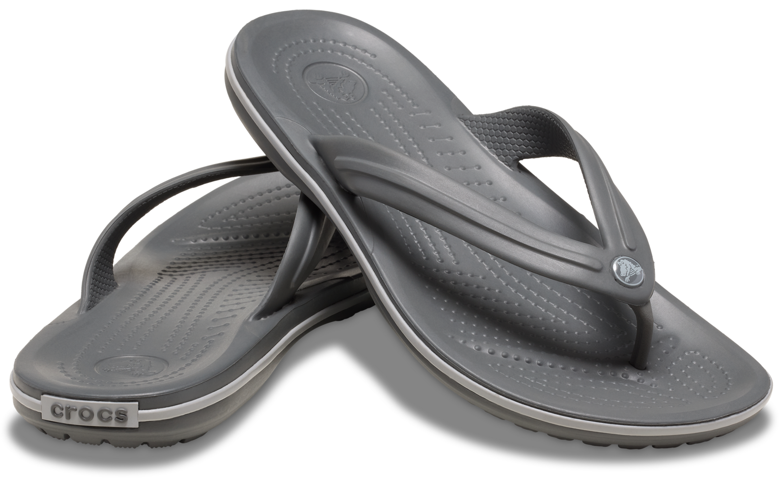 Zwei graue Zehentrenner (Flip-Flops), übereinander gelegt, sichtbares Crocs-Logo an der Ferse