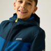 Garçon cadré de la poitrine, souriant, portant une veste à capuche bicolore bleu foncé et bleu clair, tirette de fermeture jaune et logo blanc Regatta Great Outdoors