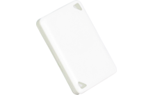 Weißes rechteckiges Kunststoffplättchen mit abgerundeten Ecken und zwei dreieckigen Aussparungen in den Ecken, schräg angeordnet, Schatten auf hellgrauem Hintergrund