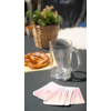 Glas Wasser, Spielkarten, Teller mit Essen und ein Topf mit grüner Pflanze auf einem Tisch
