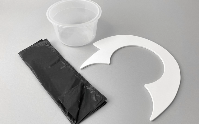 Gobelet en plastique, sac noir et feuille de papier ronde blanche avec découpes sur fond gris