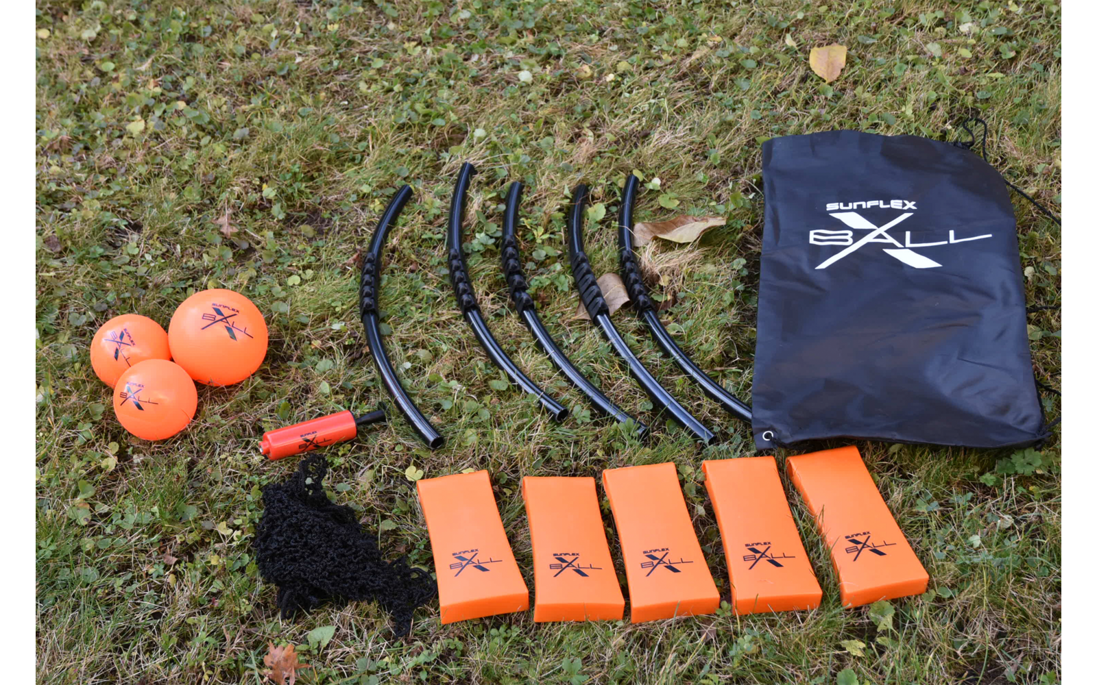 Auf einer Wiese liegen fünf orangefarbene Markierungsbojen, ein schwarzer Beutel mit weißem Totenkopf-Symbol und fünf schwarze Kabel mit Clip-Enden