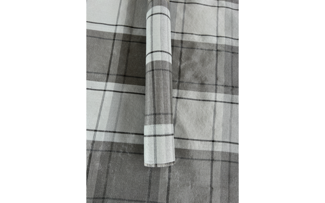 Rolle eines karierten grauen und weißen Stoffes auf einem karierten grauen und weißen Untergrund