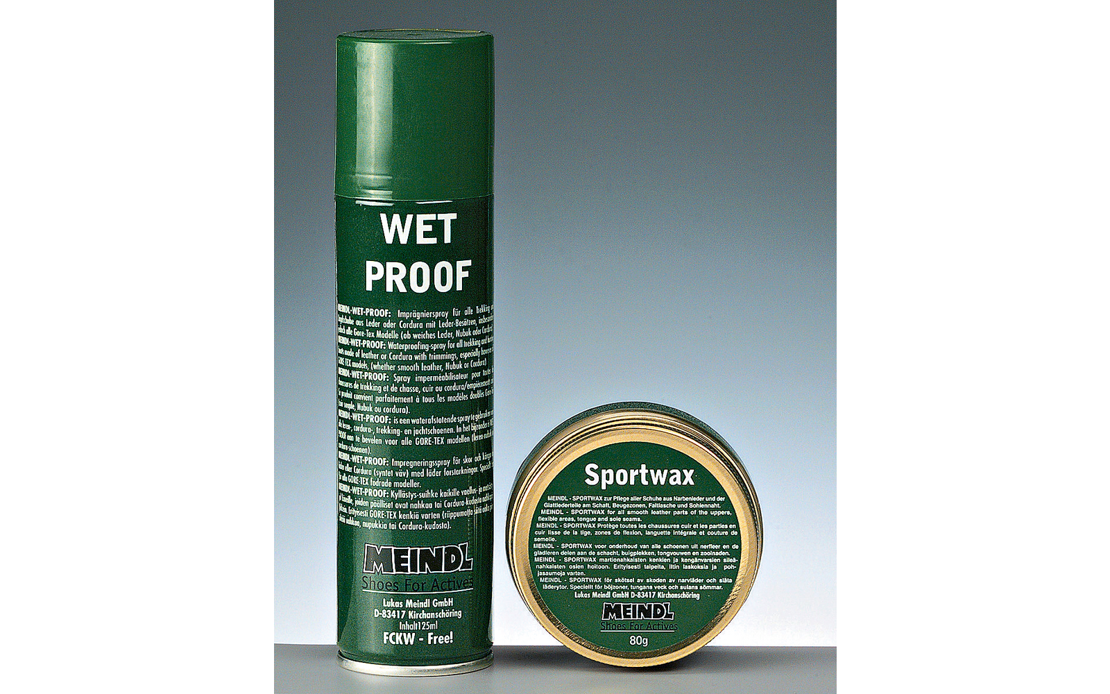Green aerosol can with large text 'WET PROOF' on the left and a round green tin labeled 'Sportwax' on the right on a neutral background
