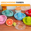 Plusieurs presse-agrumes manuels en plastique coloré sur un plan de travail en bois, un pamplemousse et un citron vert coupés en deux, une pièce de presse en verre transparent, deux bocaux de rangement avec couvercles en bois en arrière-plan