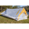 Tenda grigia con accenti gialli e scritta gialla 'KAMBU' su erba vicino a un lago e alberi