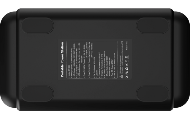 Unterseite eines schwarzen, rechteckigen Geräts mit mittig angebrachter weißer Typenplakette mit kleingedrucktem Text und vier ovalen Gummifüßen in den Ecken