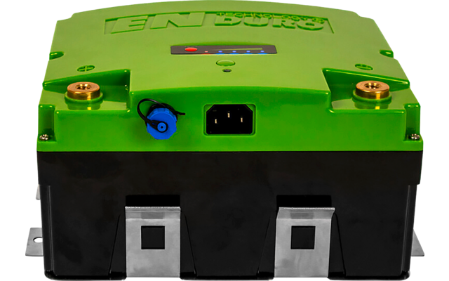 Grünes Gerät mit schwarzem Sockel, zwei Messingschrauben oben, blaue runde Buchse links, rechteckige Netzsteckerbuchse in der Mitte und drei silberne Metallanschlusslaschen unten