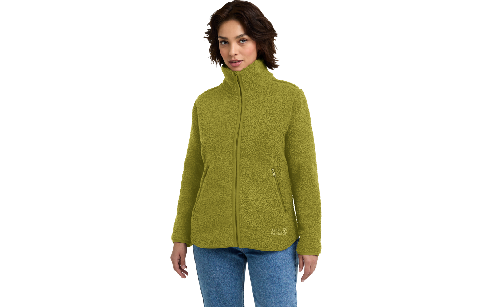 Persoon met kort donker haar draagt een olijfgroene fleecejas met hoge kraag, ritssluiting en zijzakken met rits, en een blauwe spijkerbroek op een witte achtergrond