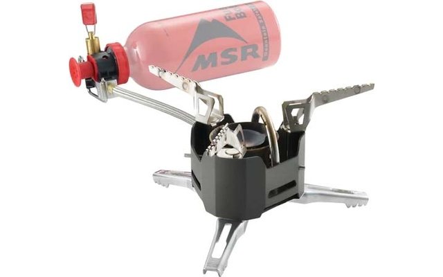 Kleiner tragbarer Kocher mit schwarzem Brenner, aufgeklappten gezahnten Metall-Töpferstützen, drei ausklappbaren Metallbeinen und einer über eine Metallleitung verbundenen roten Flasche mit MSR-Logo