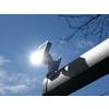 Satellitenschüssel vor blauem Himmel mit Sonne und Ästen