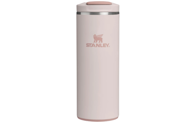 Hellrosa, zylindrischer Isolierbecher mit silbernem Ring unter dem Deckel, Vorderseite mit geflügeltem Löwenlogo und Schriftzug „STANLEY“, flacher Deckel mit rechteckigem Panel oben