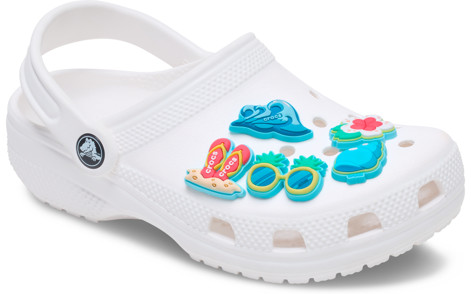 Zueco blanco con cinco adornos de zapato coloridos: gafas de sol amarillo-verde, gafas de sol turquesa-azul, chanclas rosas, sombrero de sol azul y flor rosa-azul