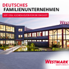 Complexe de bâtiments avec façades vitrées et fenêtres éclairées, bassin réfléchissant et avant-cour pavée; texte rouge 'DEUTSCHES FAMILIENUNTERNEHMEN', petite barre rouge 'SEIT 1956. KÜCHENHELFER FÜR DIE EWIGKEIT' et logo 'WESTMARK'