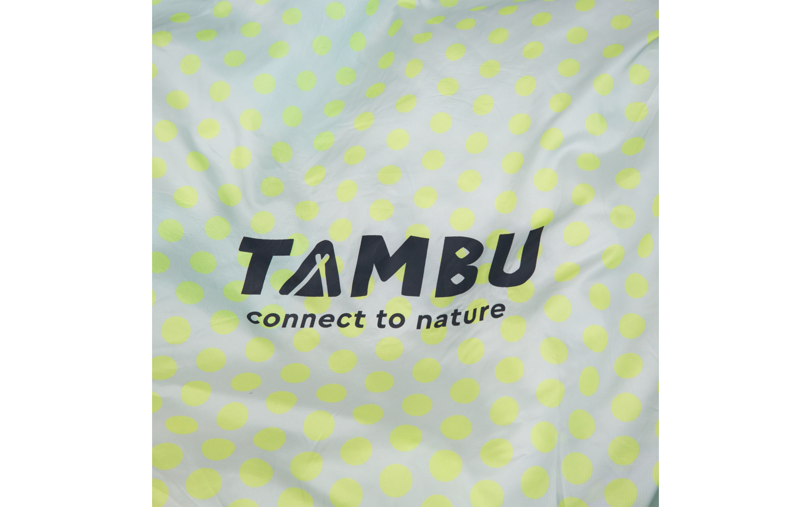 Fabric with light yellow-green polka dots and black text 'TAMBU' with the subtitle 'connect to nature'