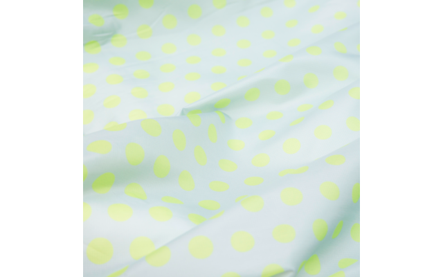 White fabric surface with light green, evenly spaced polka dots and visible folds