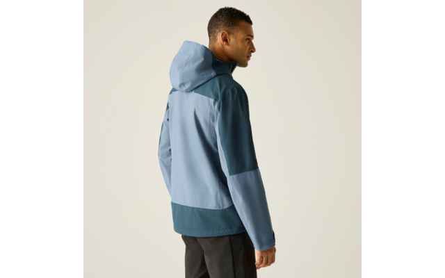 Mann von hinten im Dreiviertelprofil, trägt eine zweifarbige blaue Kapuzenjacke und dunkle Hosen vor hellem Hintergrund