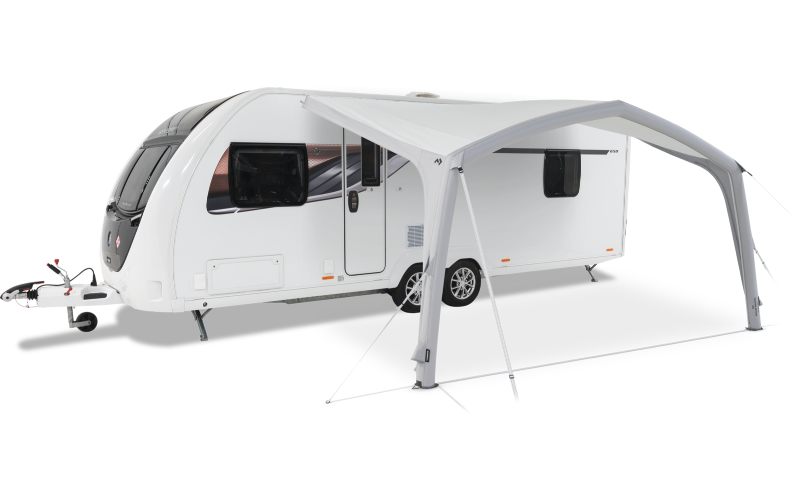 Caravan bianca con tenda grigia annessa sull'erba