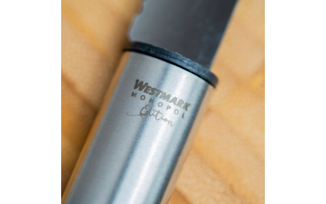 Poignée métallique avec inscription gravée WESTMARK MONOPOL Edition, anneau en plastique noir et lame foncée sur tissu jaune