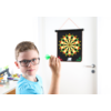 Junge mit Brille wirft Dartpfeil auf eine Dartscheibe an der Wand