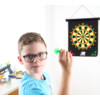 Garçon avec des lunettes lance une fléchette sur une cible accrochée au mur