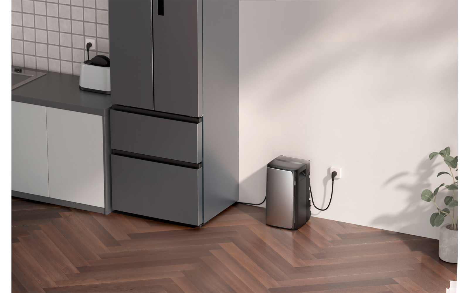 Eine graue Kaffeemaschine steht auf einem Holzfußboden neben einem grauen Schrank
