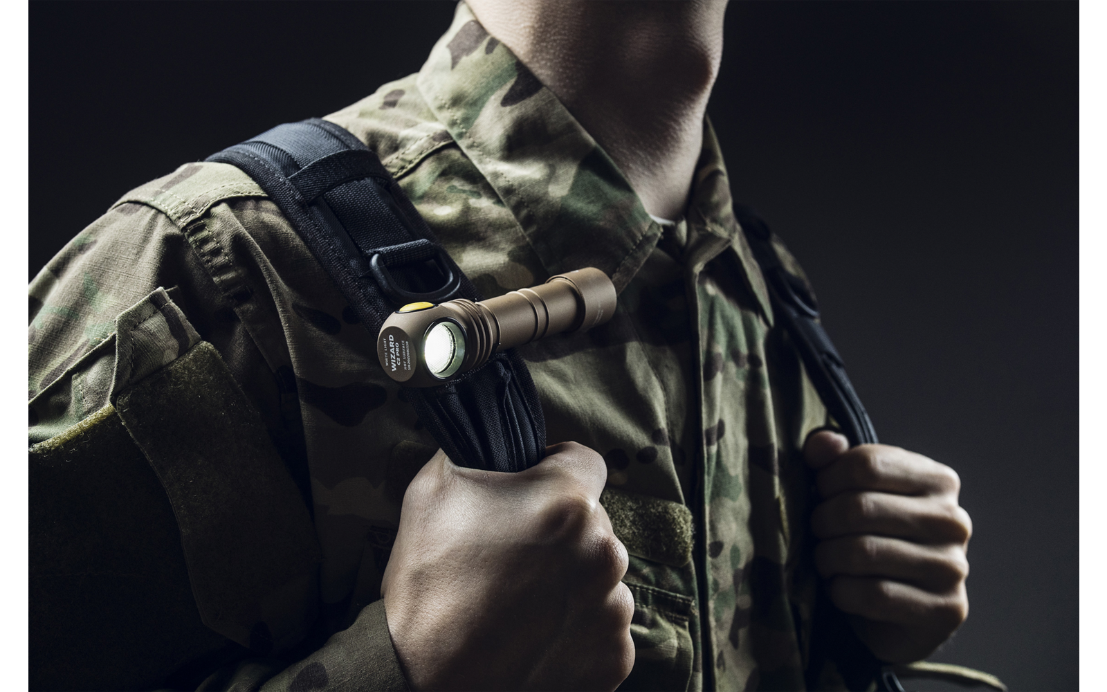 Oberkörper einer Person in Tarnuniform mit taktischem Licht an der Weste