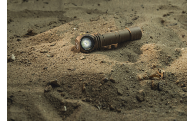 Taschenlampe liegt im Sand