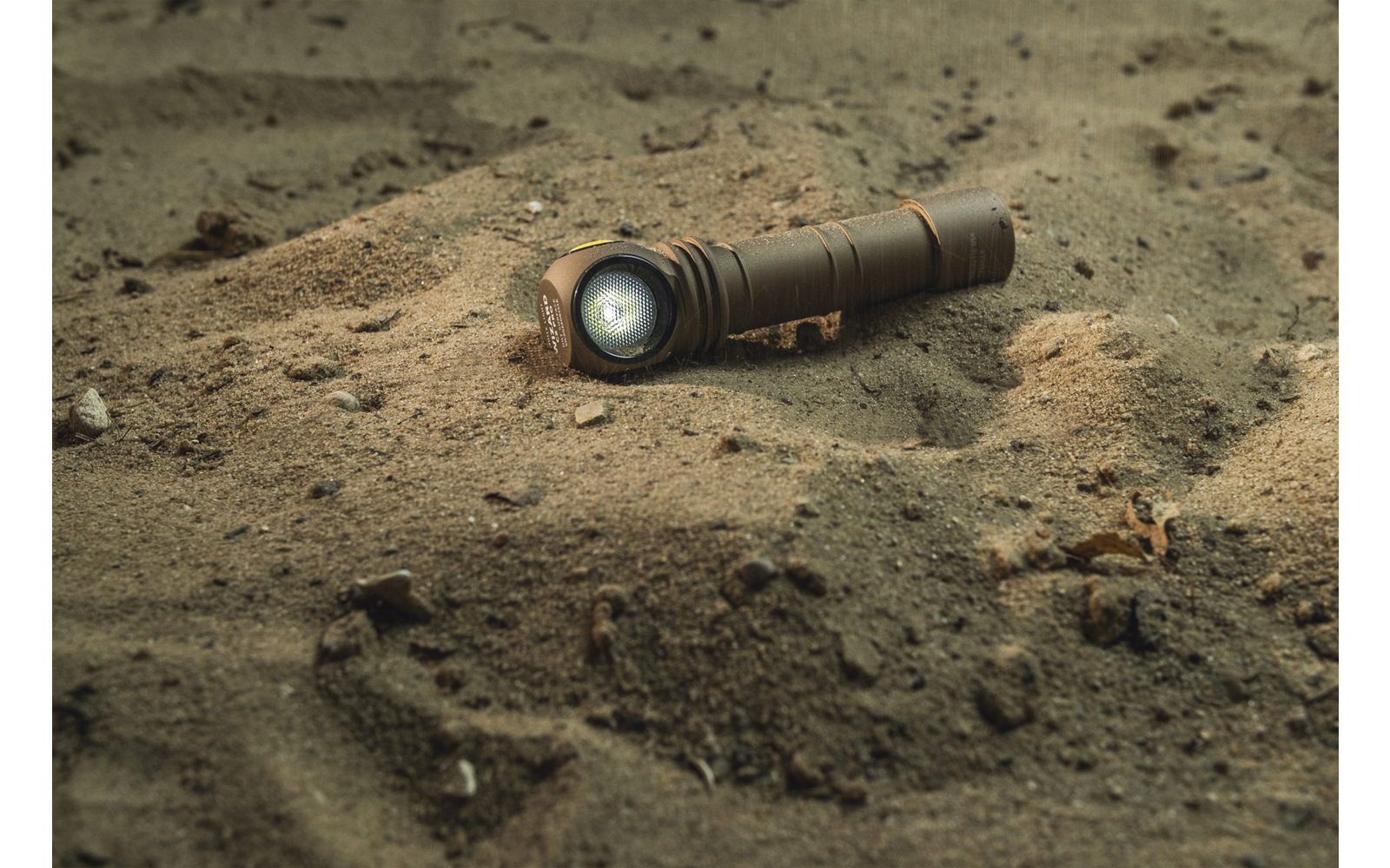 Taschenlampe liegt im Sand