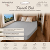 Interieur met ingebouwd French-bed, grijs hoeslaken en drie kussens, links een raam met zeezicht, houten kast rechts, 'PRIMERA TRAVEL'-logo en tekstbalken met maat- en materiaalgegevens