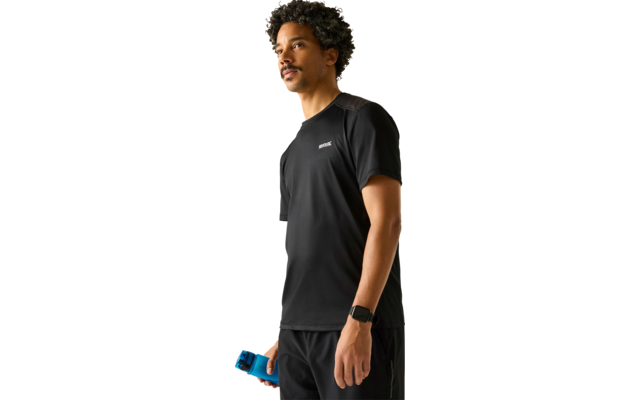 Person in schwarzem Sportshirt und Shorts, hält eine blaue Trinkflasche, trägt eine Smartwatch, steht vor hellem Hintergrund und blickt nach rechts