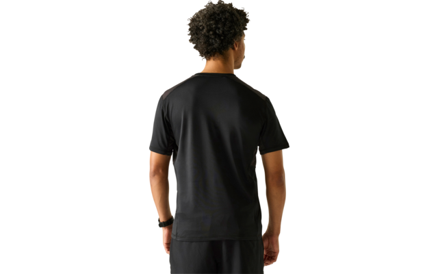 Person von hinten, trägt schwarzes T-Shirt und schwarze Shorts, kurzes lockiges Haar, hellgrauer Hintergrund, Armbanduhr am linken Handgelenk