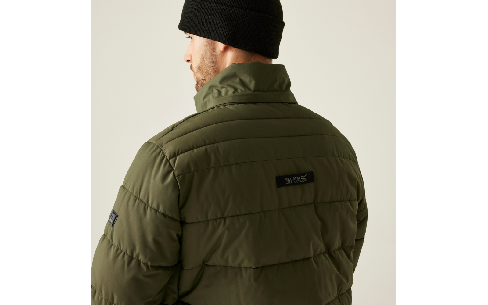 Mann von hinten, trägt eine grüne Steppjacke und eine schwarze Mütze