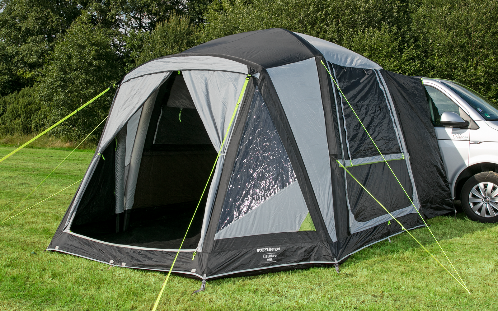Zelt neben einem weißen Fahrzeug auf einer grünen Wiese unter blauem Himmel mit Wolken