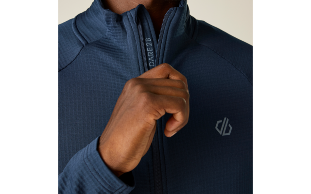 Nahaufnahme einer Hand, die den Reißverschluss einer dunkelblauen Jacke hochzieht; weißes geometrisches Logo auf der Brust; Reißverschlussanhänger mit Schriftzug "DARE2B"