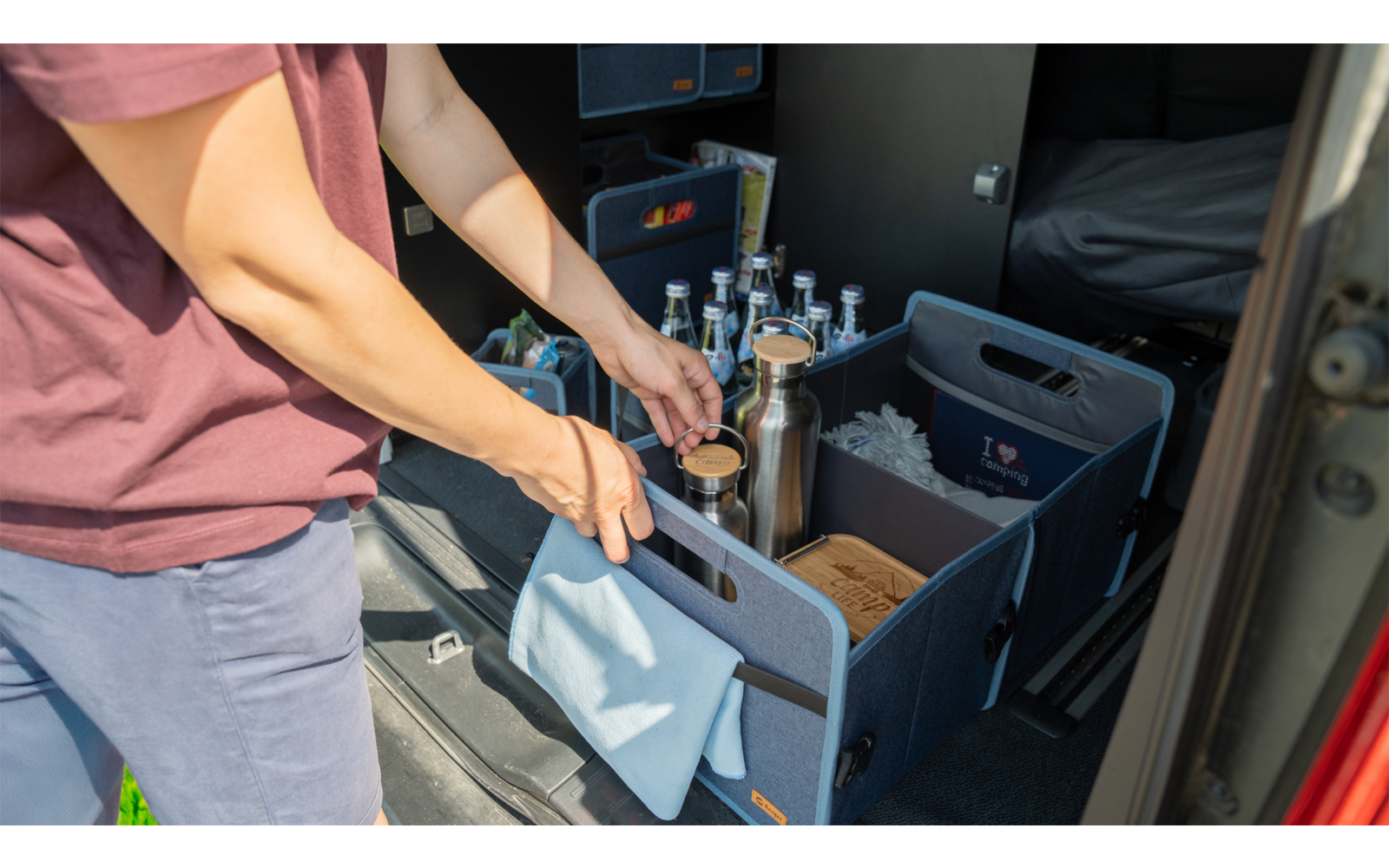 Deux personnes déchargent des colis d'un véhicule dans une caisse