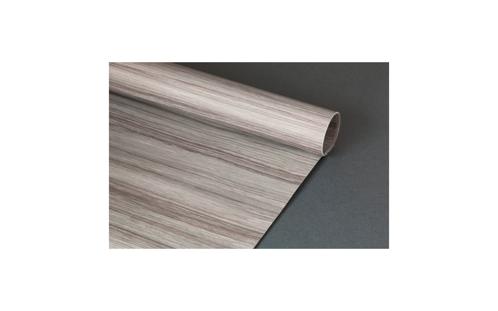 Aufgerollte Folie mit hellbraunen und grauen Holzmaserungen auf dunklem Hintergrund