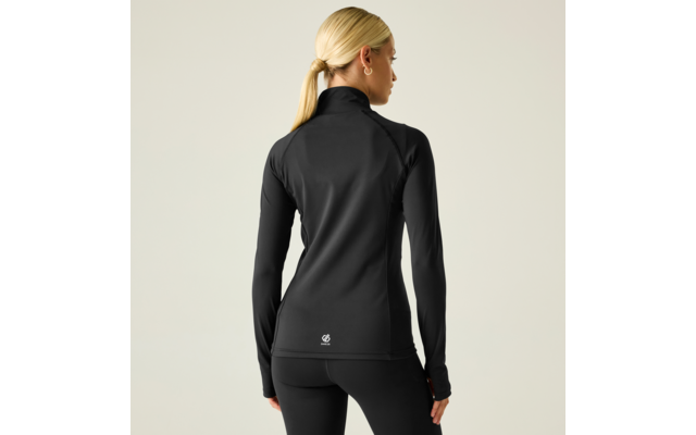 Mujer vista de espaldas, coleta rubia, chaqueta deportiva negra ajustada con cremallera y mallas negras, fondo claro, cabeza girada a la derecha