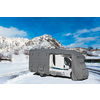 Ein Wohnmobil mit grauer Abdeckung auf schneebedecktem Boden vor schneebedeckten Bergen und blauem Himmel