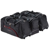 Trois sacs de voyage noirs à roulettes avec fermetures éclair, bordures rouges et poignées, côte à côte sur fond blanc