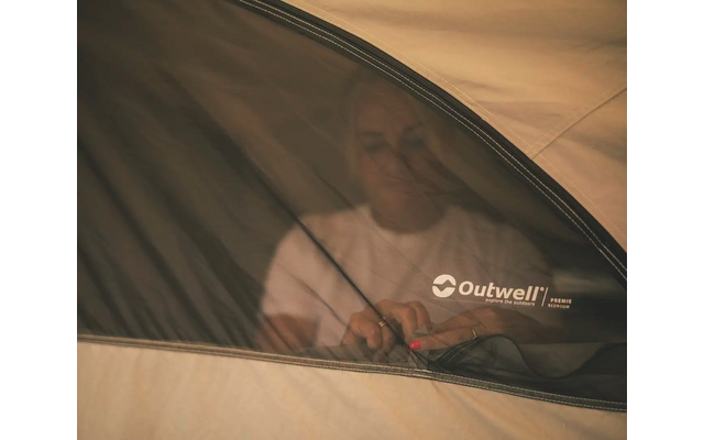 Mann sitzend hinter einem Zeltfenster mit dem Logo Outwell