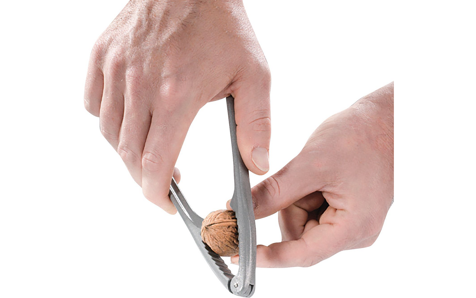 Dos manos sostienen un cascanueces con una nuez entre sus mordazas