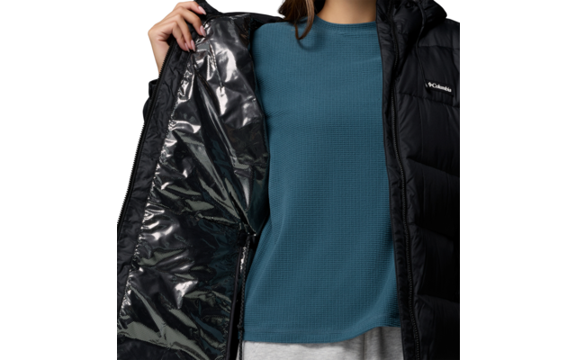 Person hält eine schwarze, glänzende Jacke geöffnet, trägt einen blauen Pullover
