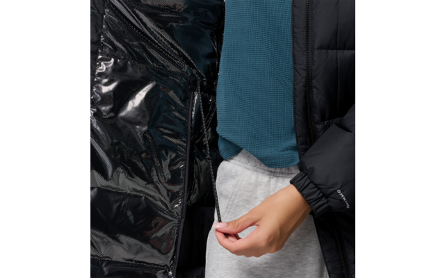 Hand greift an Hosenbund einer Person mit blauer Jacke und schwarzer Jacke im Hintergrund