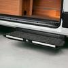 Geöffnete Seitentür eines Fahrzeugs, ausgeklappte dunkelgraue, mit Teppich bezogene Trittstufe, sichtbarer Holzinnenausbau