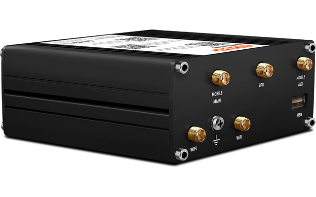 Schwarzes rechteckiges Metallgehäuse mit mehreren goldfarbenen Antennenanschlüssen, einem USB‑Anschluss, Schrauben an den Ecken und einem Aufkleber mit QR‑Code auf der Oberseite