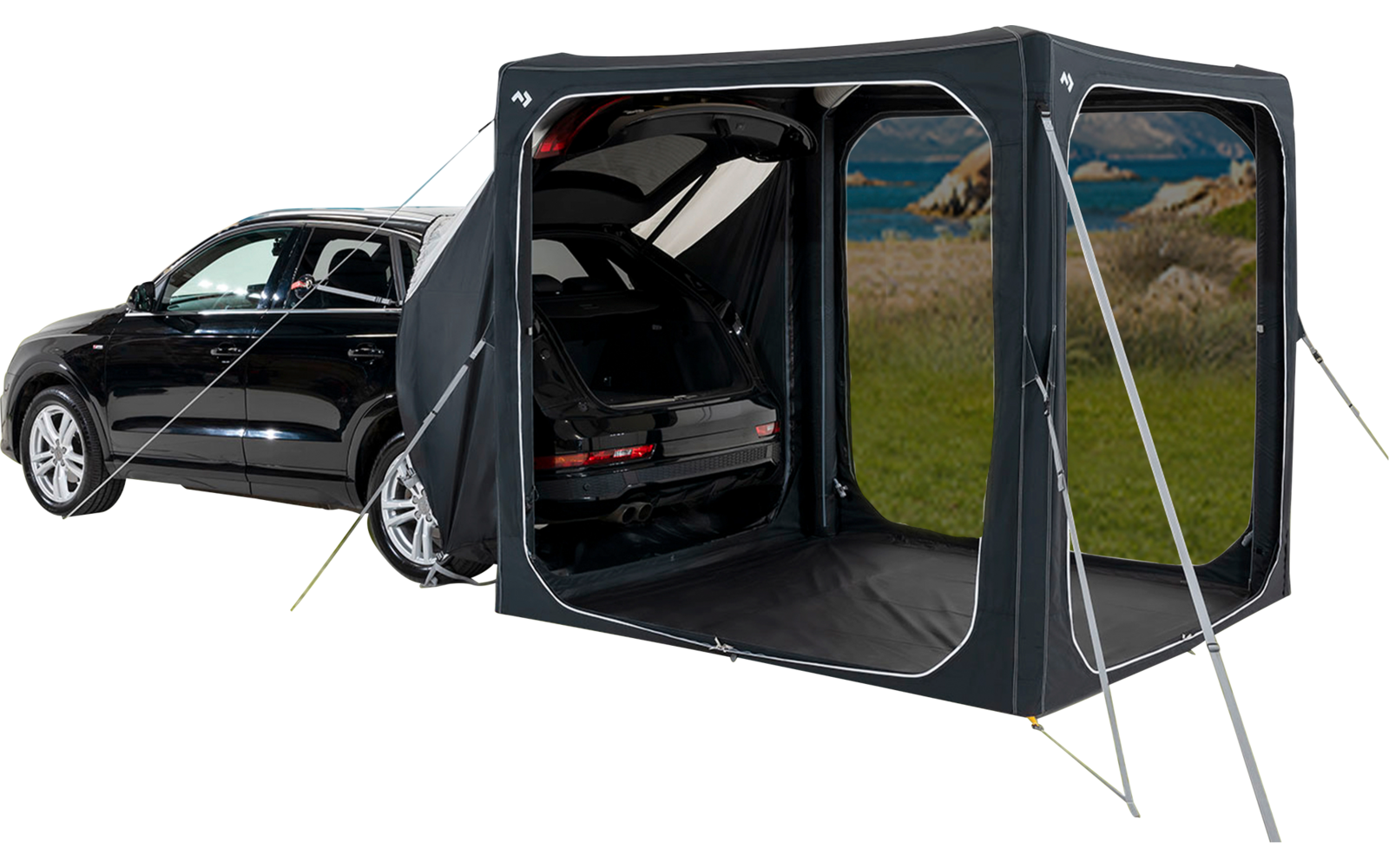 Zwarte auto op een grasveld met een aangebouwde tentuitbreiding en open kofferbak