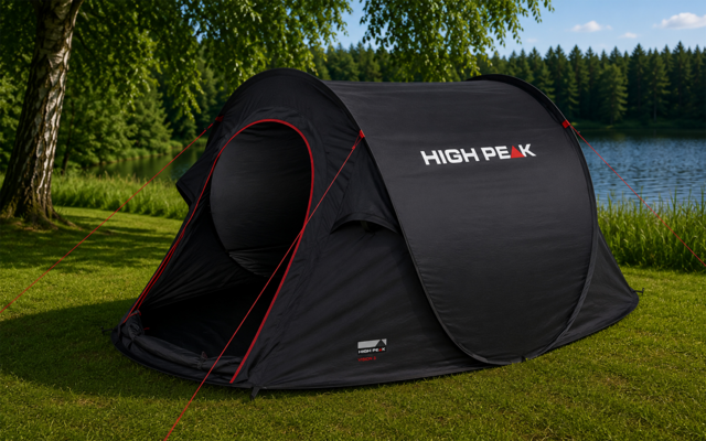 Zwart pop-up tent met open ingang, wit 'HIGH PEAK'-logo en rode scheerlijnen op gras bij een meer; bomen en blauwe lucht op de achtergrond