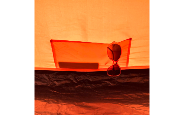 Lunettes de soleil suspendues à une poche intérieure d'une tente orange